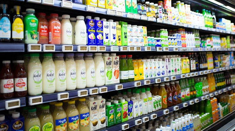 Estantería refrigerada de supermercado con bebidas fermentadas, una forma de comprar kéfir ya preparado